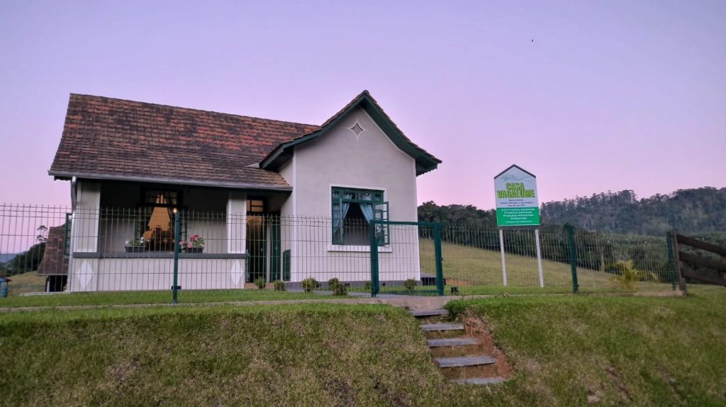 Casa Vagalume ao entardecer no bairro Rio da Luz, em Jaraguá do Sul, com paisagem rural ao fundo