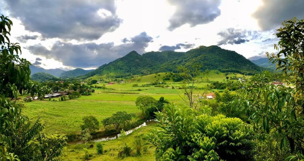 Vista panorâmica do Vale Tombado em Rio da Luz, com montanhas verdes e céu dramático ao fundo